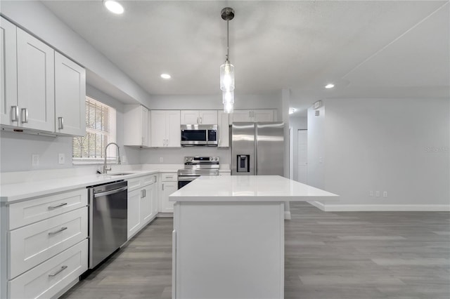 kitchen with a center island, a sink, light wood-style flooring, appliances with stainless steel finishes, and recessed lighting