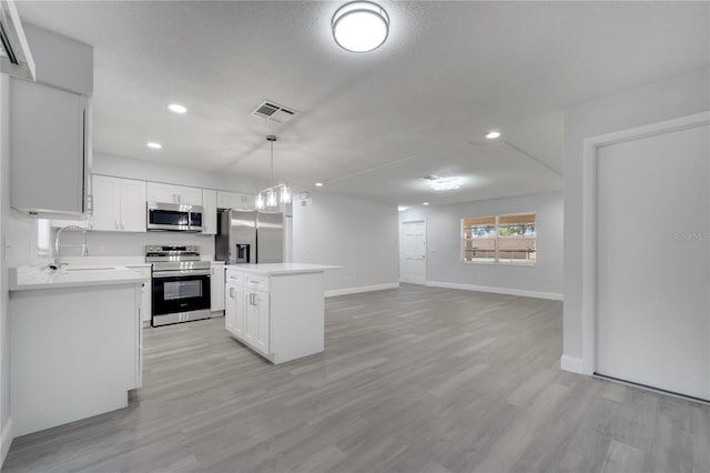 kitchen with recessed lighting, visible vents, a sink, a center island, and appliances with stainless steel finishes
