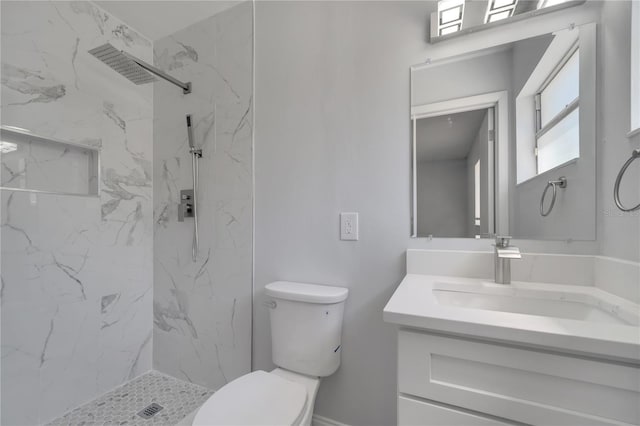 bathroom featuring a marble finish shower, vanity, and toilet