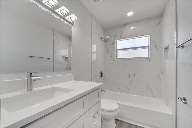 bathroom with wood finished floors, vanity, shower / tub combination, and toilet