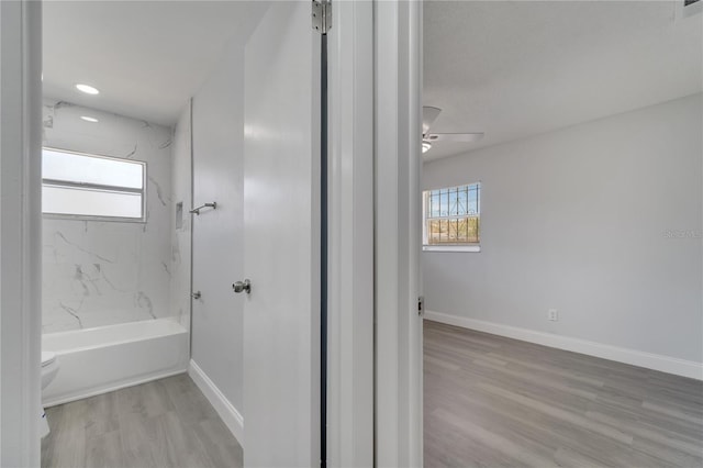 full bathroom with wood finished floors, toilet, baseboards, shower / tub combination, and ceiling fan
