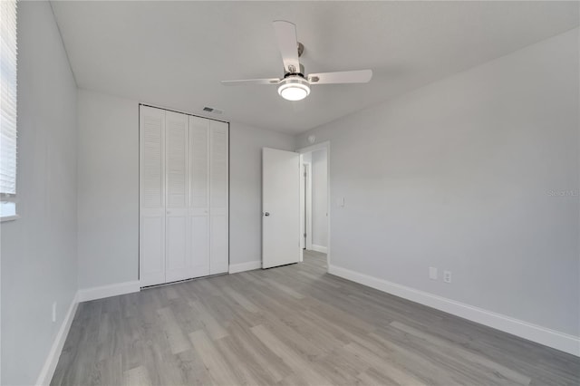 unfurnished bedroom featuring visible vents, a ceiling fan, light wood-type flooring, a closet, and baseboards