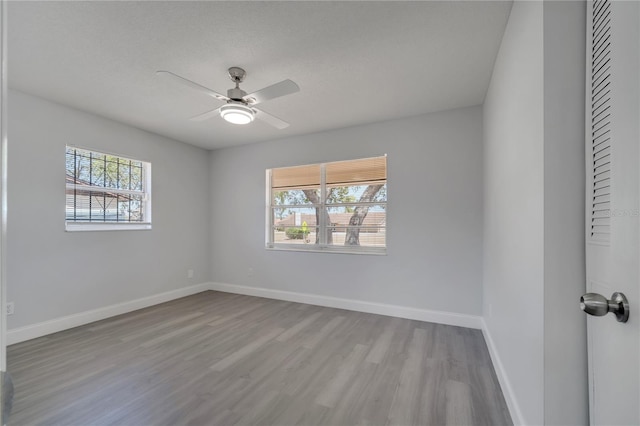 unfurnished room with baseboards, wood finished floors, and ceiling fan