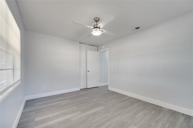 unfurnished bedroom featuring light wood-style floors, visible vents, a ceiling fan, and baseboards