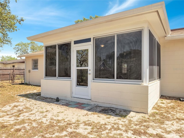 rear view of house with fence and concrete block siding