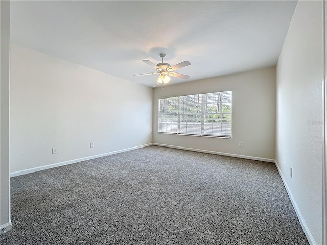empty room featuring carpet, a ceiling fan, and baseboards
