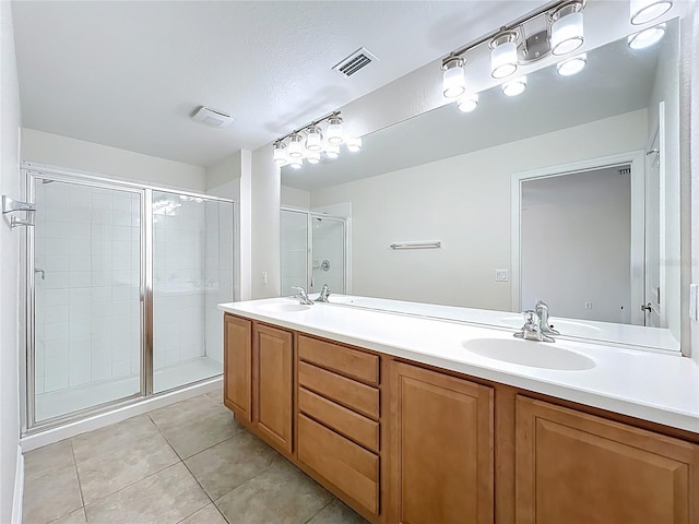 bathroom featuring a shower stall, visible vents, tile patterned flooring, and a sink