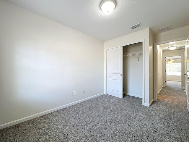 unfurnished bedroom with a closet, carpet, visible vents, and baseboards