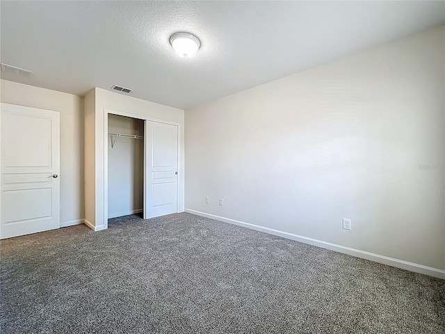 unfurnished bedroom with baseboards, visible vents, carpet, and a closet