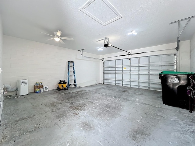 garage featuring concrete block wall, a ceiling fan, and a garage door opener