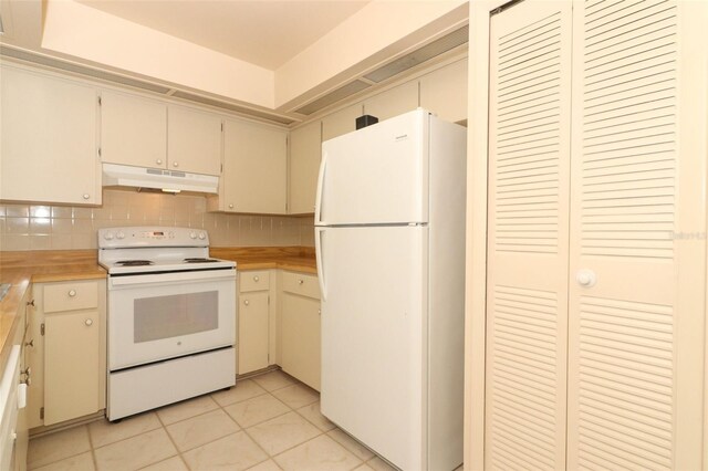 406 Red Coat Ln, Orlando, FL 32825 - kitchen with white appliances, under cabinet range hood, light countertops, light tile patterned flooring, and decorative backsplash