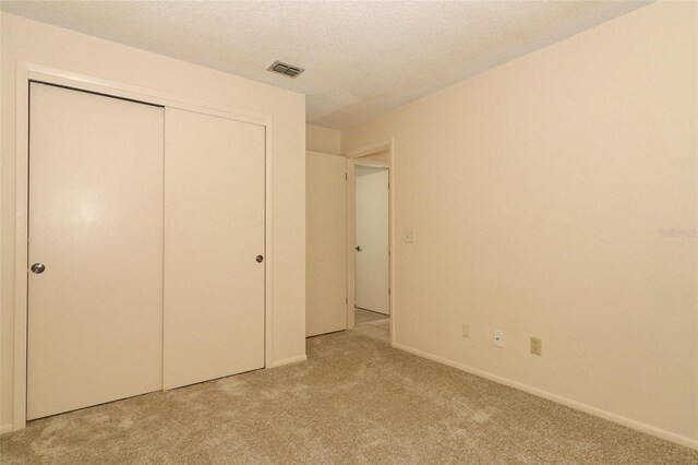 406 Red Coat Ln, Orlando, FL 32825 - unfurnished bedroom with light carpet, a closet, a textured ceiling, and baseboards