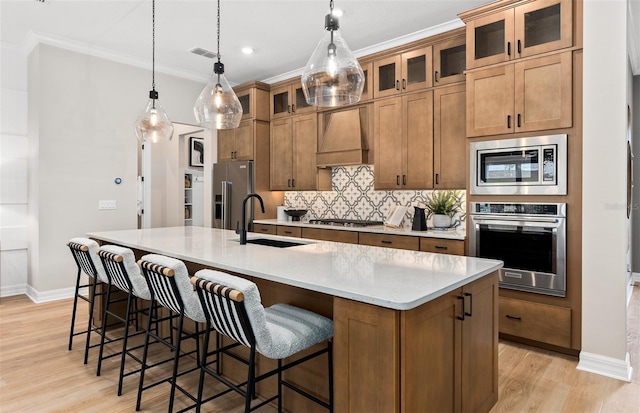 kitchen with baseboards, a sink, stainless steel appliances, and custom range hood