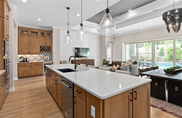 kitchen with crown molding, brown cabinetry, appliances with stainless steel finishes, and a sink