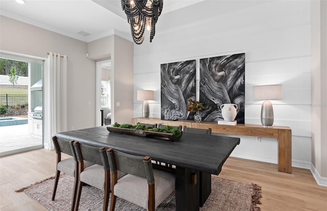 dining room with baseboards, ornamental molding, a chandelier, and light wood-type flooring
