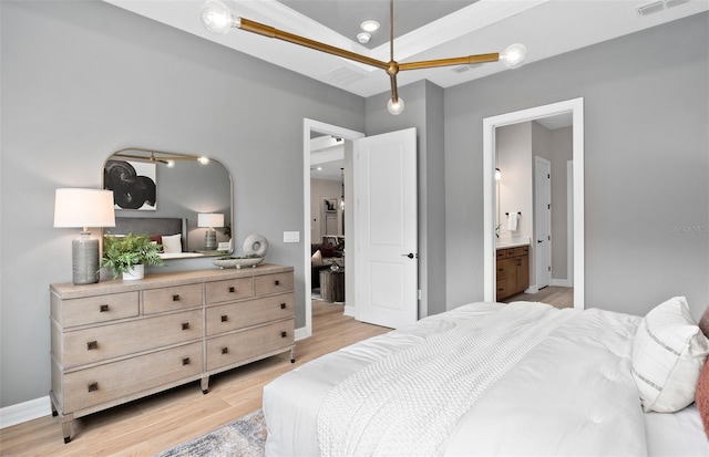 bedroom featuring connected bathroom, baseboards, visible vents, and light wood-type flooring