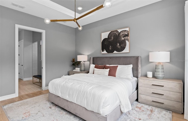 bedroom with light wood-type flooring, visible vents, and baseboards