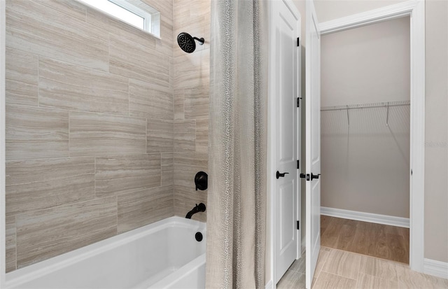 full bathroom with a walk in closet and shower / bath combination with curtain
