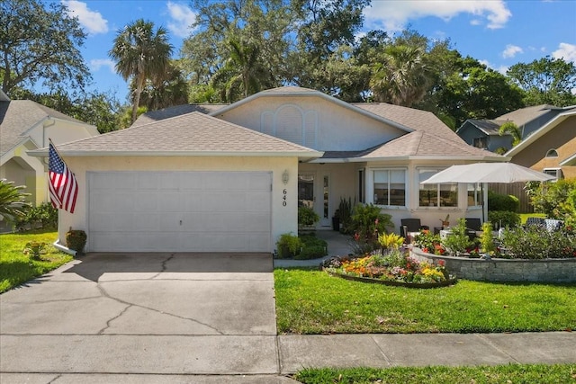 single story home featuring an attached garage, a front lawn, concrete driveway, and roof with shingles