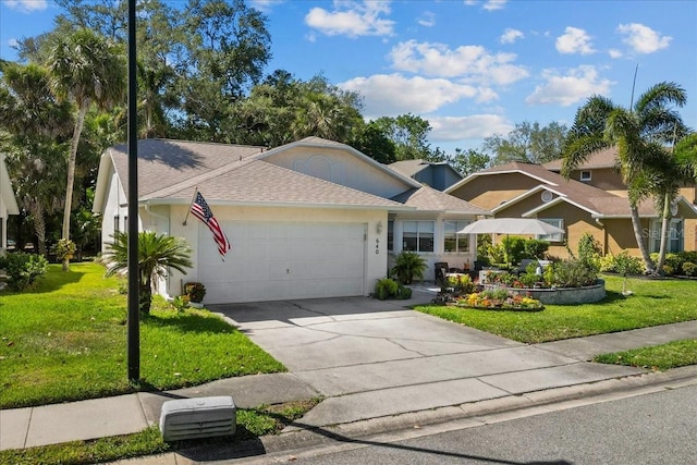 single story home featuring concrete driveway, an attached garage, a shingled roof, and a front yard