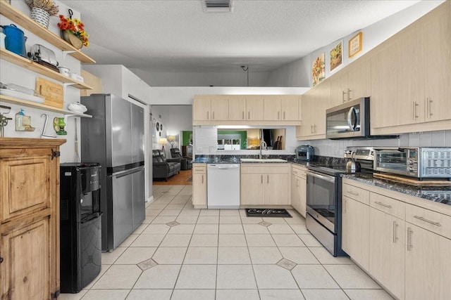 kitchen with light brown cabinetry, a sink, visible vents, open shelves, and appliances with stainless steel finishes