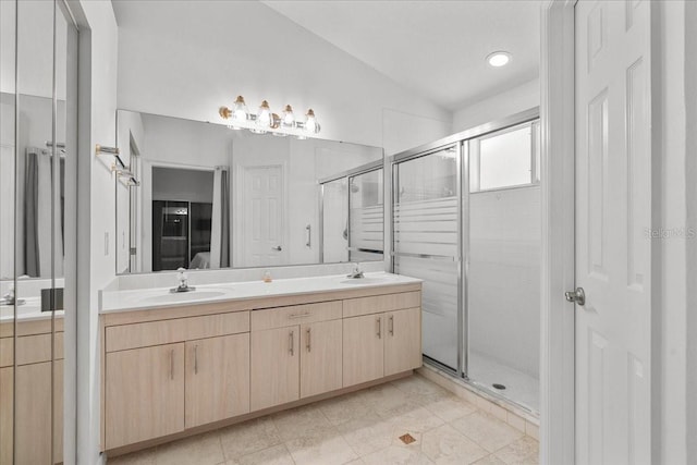 ensuite bathroom with a sink, double vanity, and a stall shower