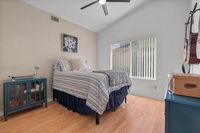 bedroom featuring vaulted ceiling, baseboards, visible vents, light wood-style floors, and ceiling fan