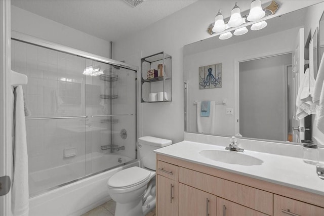 bathroom featuring bath / shower combo with glass door, toilet, vanity, and tile patterned floors