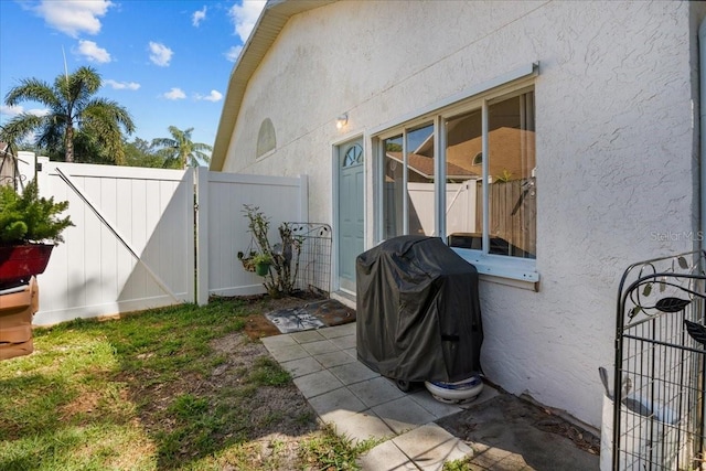 view of property exterior featuring fence, a gate, and stucco siding