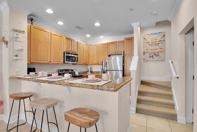 2840 Bella Vista Dr, Davenport, FL 33897 - kitchen featuring a peninsula, recessed lighting, a kitchen bar, crown molding, and appliances with stainless steel finishes