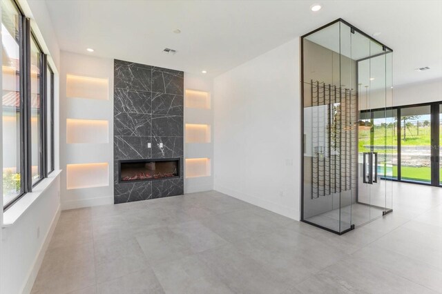 16825 Bolsena Dr, Montverde, FL 34756 - unfurnished living room featuring a premium fireplace and recessed lighting
