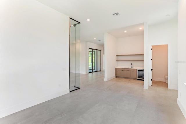 16825 Bolsena Dr, Montverde, FL 34756 - unfurnished living room featuring wine cooler, recessed lighting, and finished concrete floors