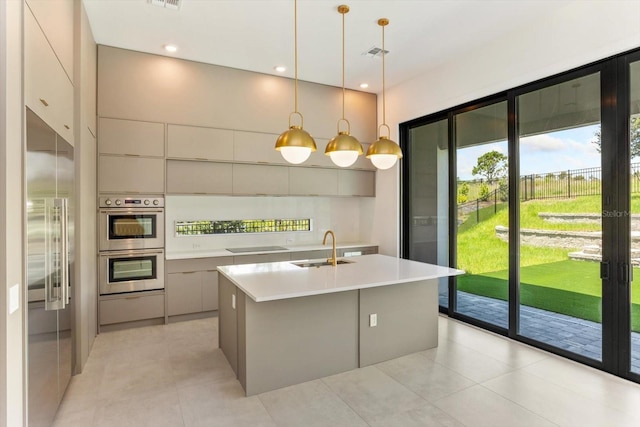16825 Bolsena Dr, Montverde, FL 34756 - kitchen featuring stainless steel appliances, modern cabinets, light countertops, and a kitchen island with sink