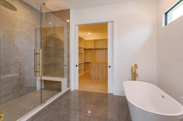 16825 Bolsena Dr, Montverde, FL 34756 - bathroom featuring a stall shower, a spacious closet, a freestanding bath, marble tiled floors, and recessed lighting