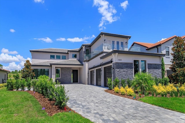 16825 Bolsena Dr, Montverde, FL 34756 - view of front of house with stone siding, a garage, decorative driveway, and stucco siding
