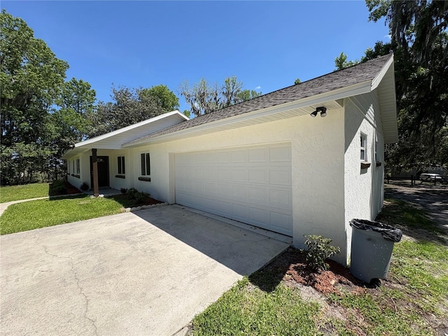 ranch-style home featuring a garage, driveway, and stucco siding