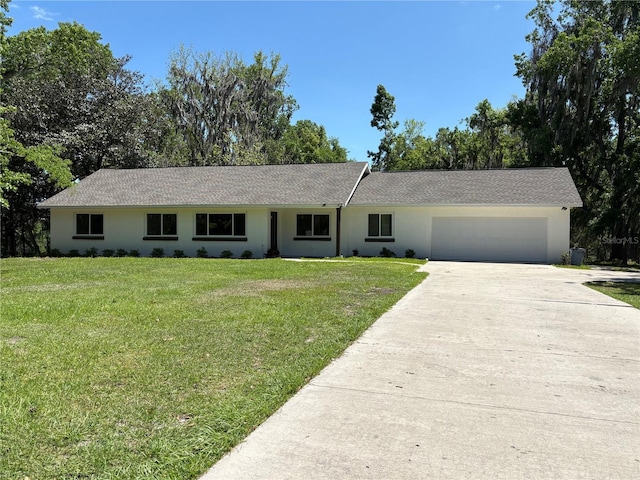 ranch-style house with concrete driveway, stucco siding, a front yard, and a garage