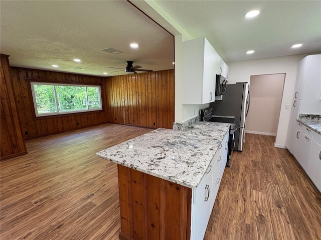 kitchen featuring white cabinets, range with electric stovetop, wood finished floors, and recessed lighting