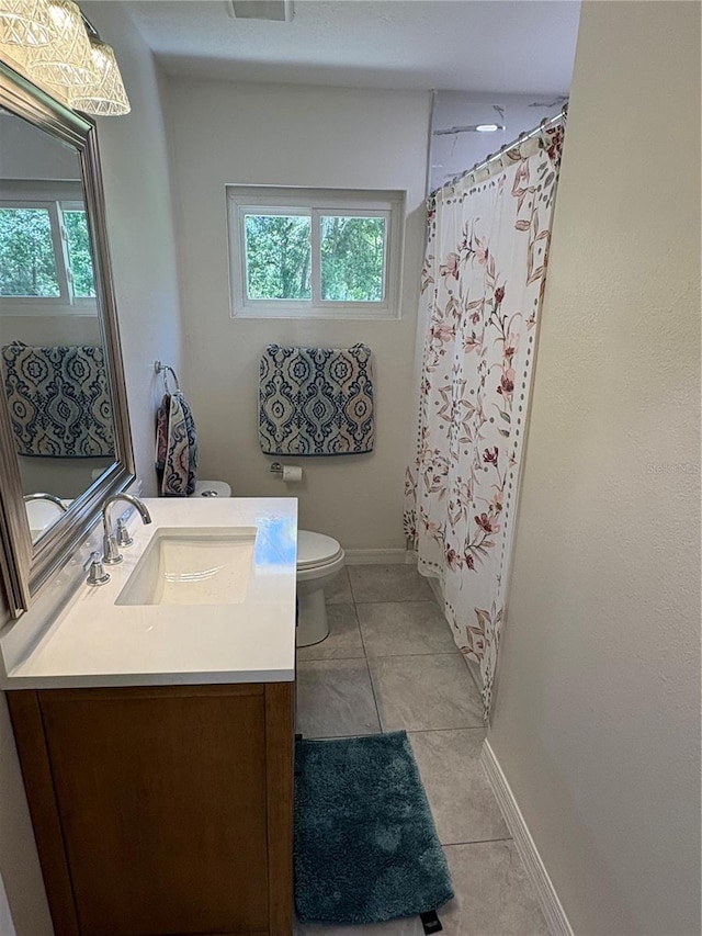 full bath featuring toilet, vanity, tile patterned floors, and baseboards