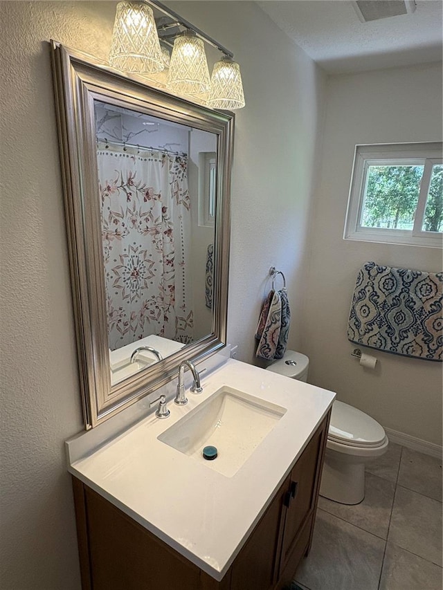 bathroom with a shower with curtain, vanity, tile patterned flooring, and toilet