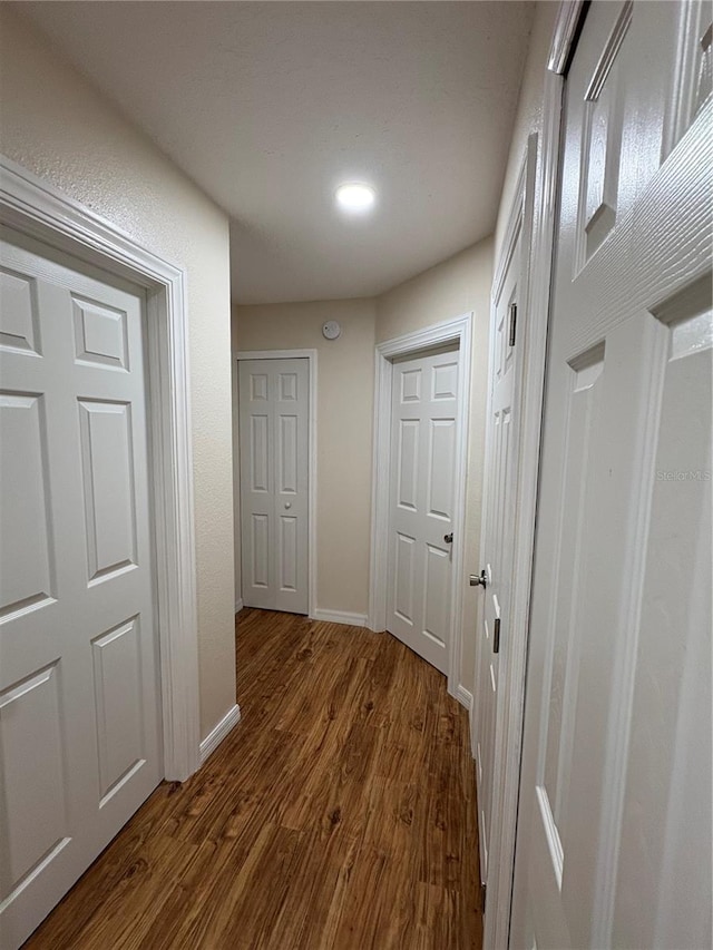 hall with dark wood finished floors and baseboards
