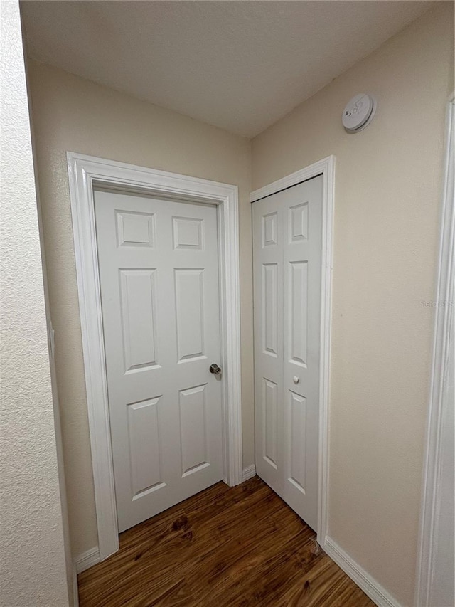 interior space with baseboards and dark wood-style floors