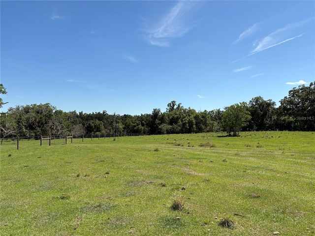 view of yard featuring a rural view and fence