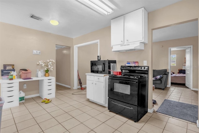 kitchen with white cabinets, under cabinet range hood, black appliances, and light tile patterned flooring