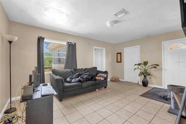 living room featuring baseboards, visible vents, and light tile patterned floors