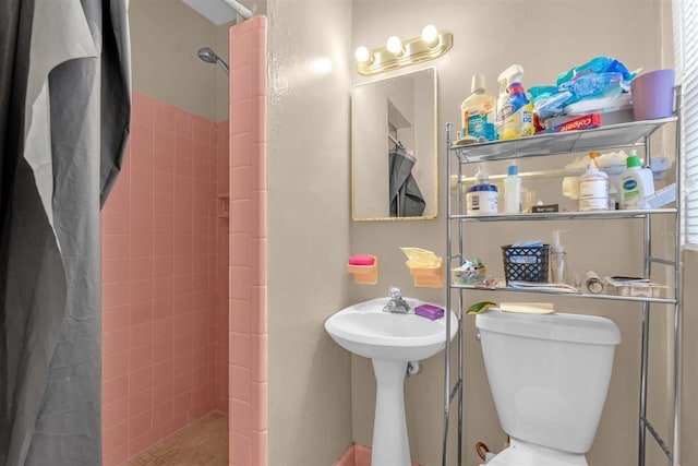 full bathroom featuring toilet and tiled shower