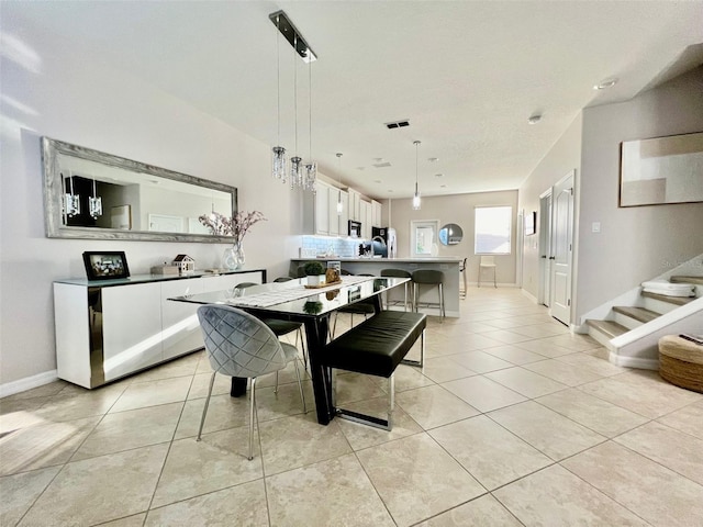 dining area with baseboards, light tile patterned flooring, stairs, and visible vents