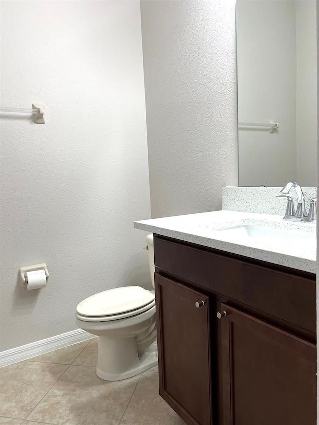 bathroom featuring tile patterned floors, baseboards, vanity, and toilet