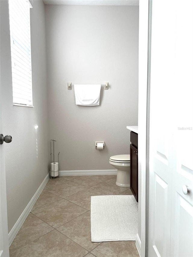 bathroom with tile patterned floors, baseboards, vanity, and toilet
