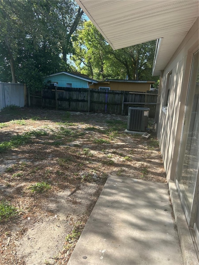 view of yard featuring cooling unit, a patio area, and fence